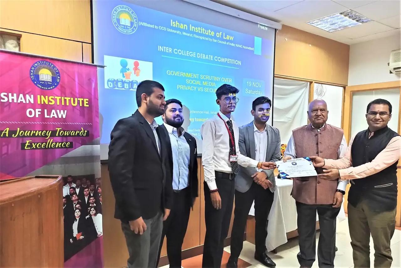 Dr. Tushar Arya awarding certificates to winners of debate competition at Best Law College.
